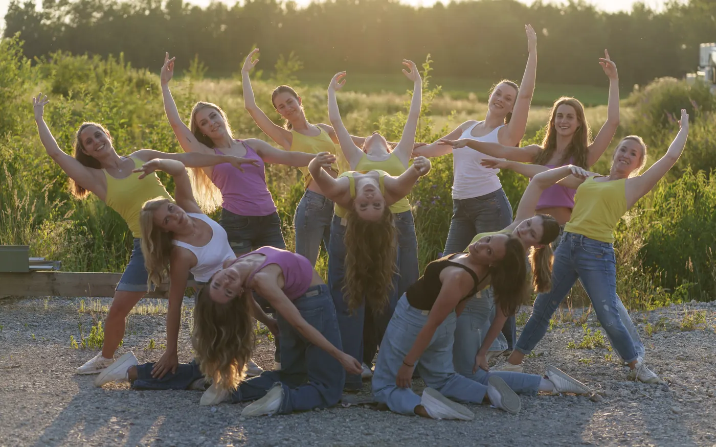 Große Gruppe junger Tänzerinnen in Jeans bei Abendsonne, in einer gemeinsamen Pose