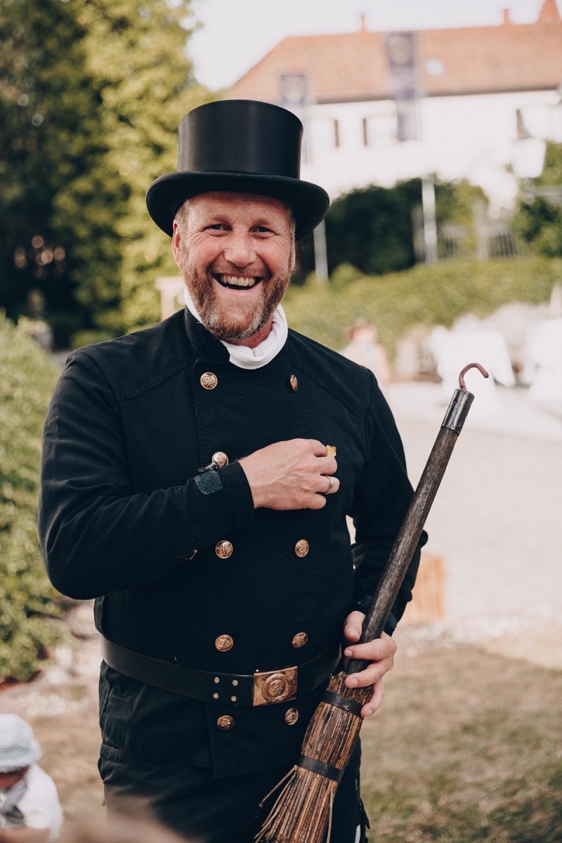 Martin Arpogaus, Schornsteinfegermeister, in Zunftkleidung mit Zylinder und Kehrbesen